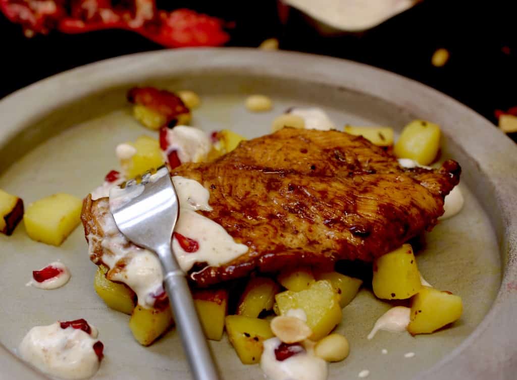 Easy tamarind chicken and cumin potatoes on plate with pomegranate