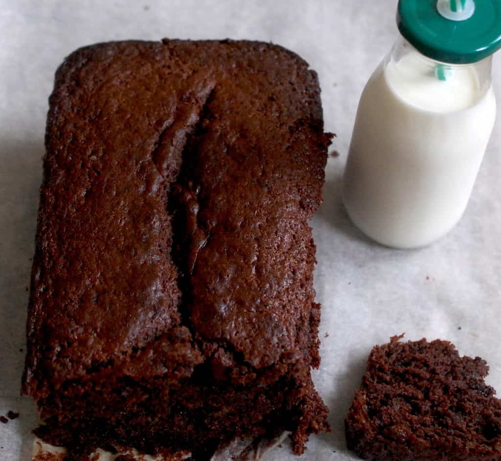 Chocolate and banana bread on baking paper with a small bottle of milk 
