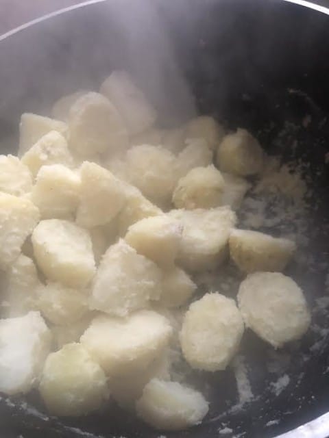 Steamed Potatoes with rough edges in pot
