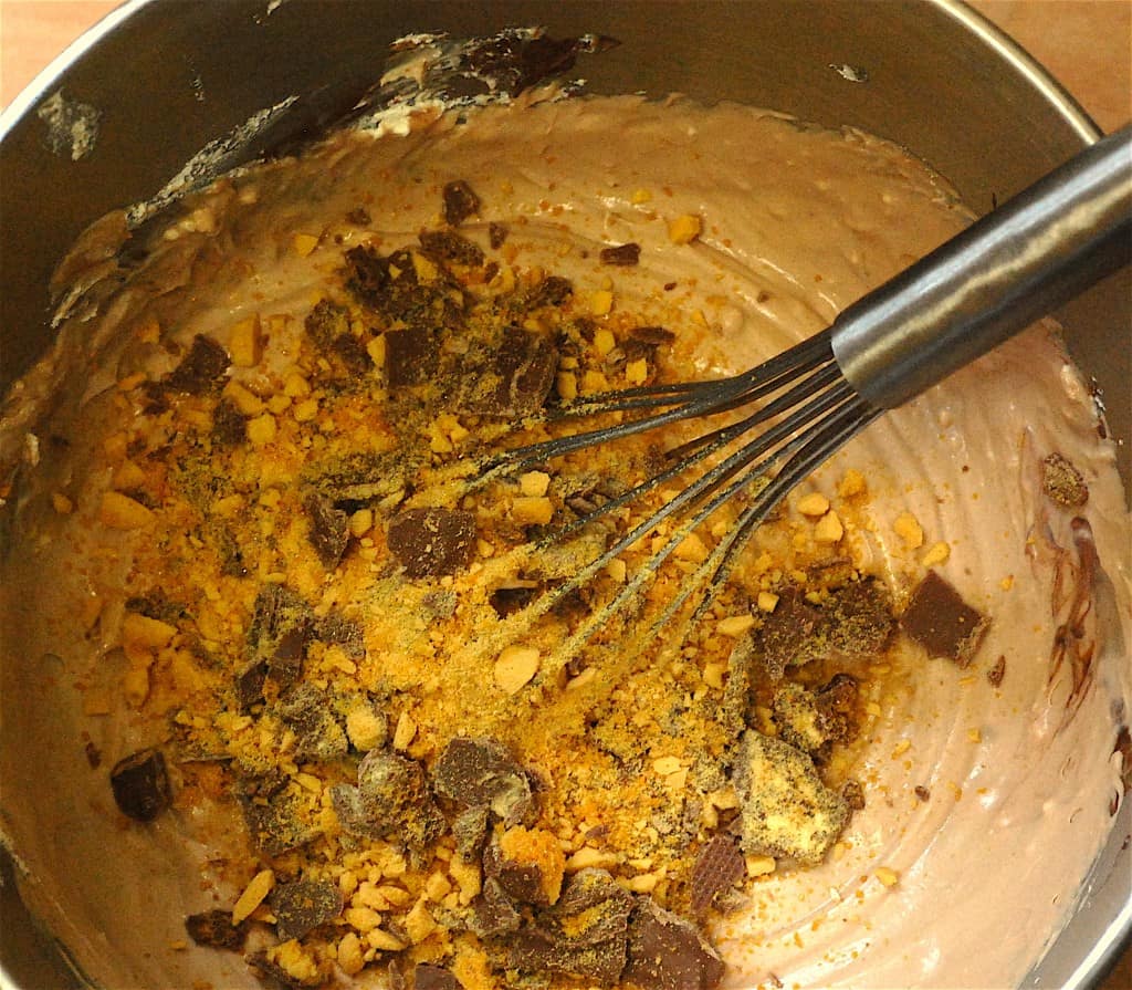 Ice cream ingredients and broken crunchie bars being whisked in bowl