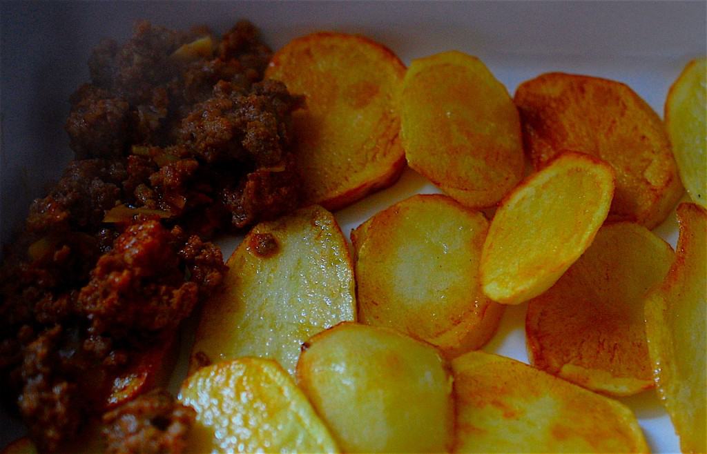 Mince meat layered on some cooked potato slices