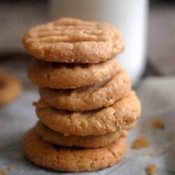 Peanut butter cookies in a pile with milk in background