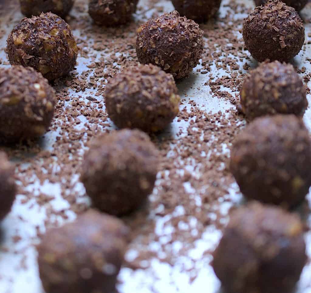 Date balls with chocolate shavings surrounding 