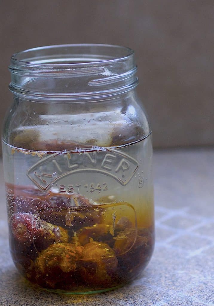 Dates in a Kilner Jar filled with water on a grey tile