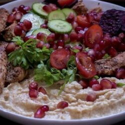 Chicken, Salad, Pomegranate and Hummus in a bowl
