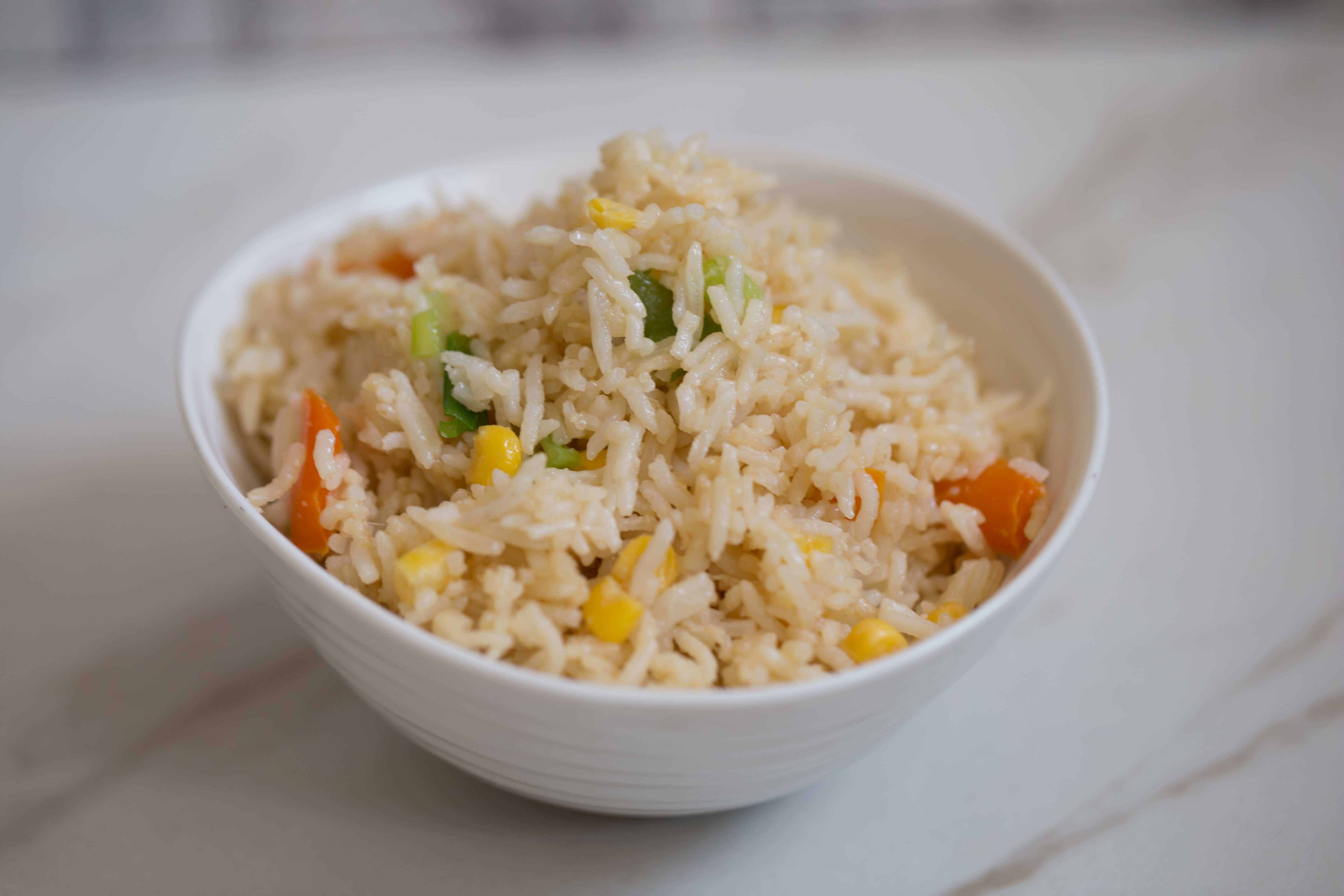 Egg Fried Rice with veg in white bowl on table