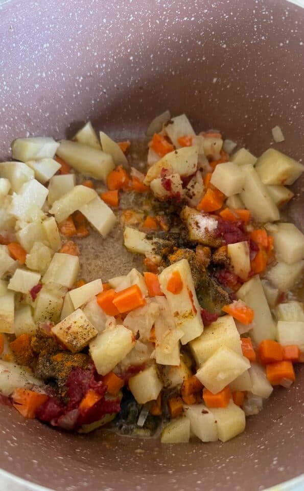 Tomato paste and spices added to pot