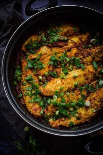 Masala Fish in a pan topped with spring onions and coriander