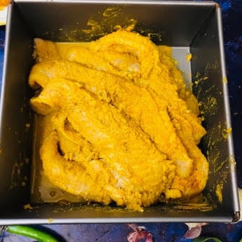 Fish marinaded in spices in a grey tin