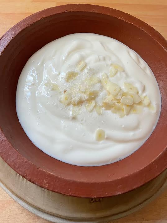 Garlic added to yoghurt in bowl