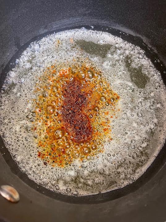 Chilli and paprika added to butter in pan