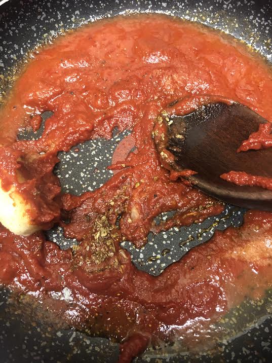 Tomato, Garlic, Salt and Oregano being heated in pan