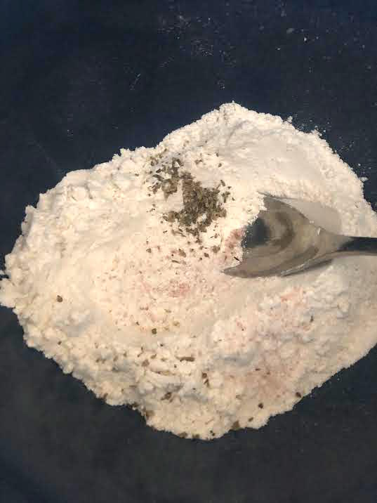 Flour, Salt, Oregano in a bowl with a spoon