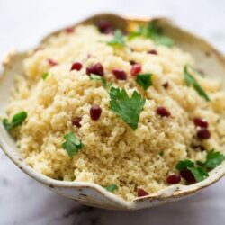 Lemon and Pomegranate Couscous in bowl on a marble background