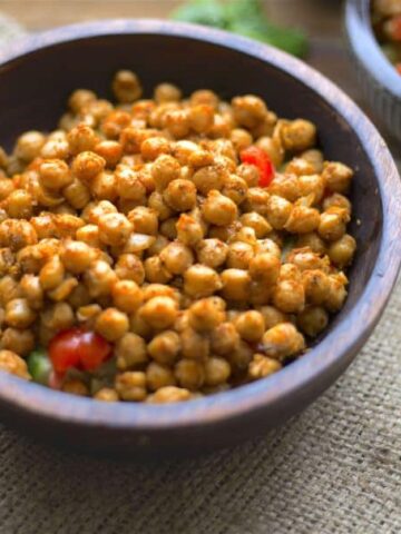 Two bowls with spiced chickpeas on a bed of salad
