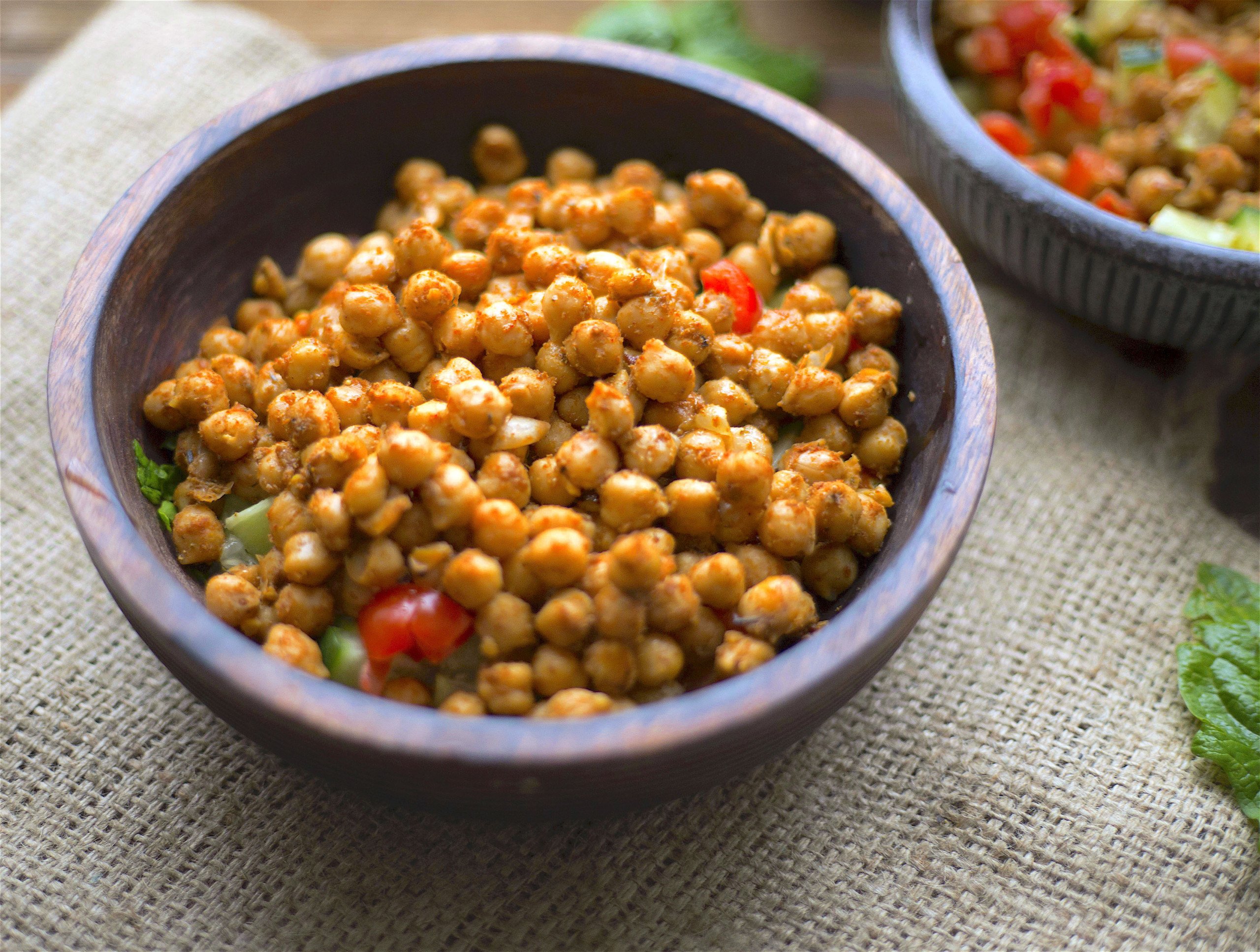 Two bowls with spiced chickpeas on a bed of salad