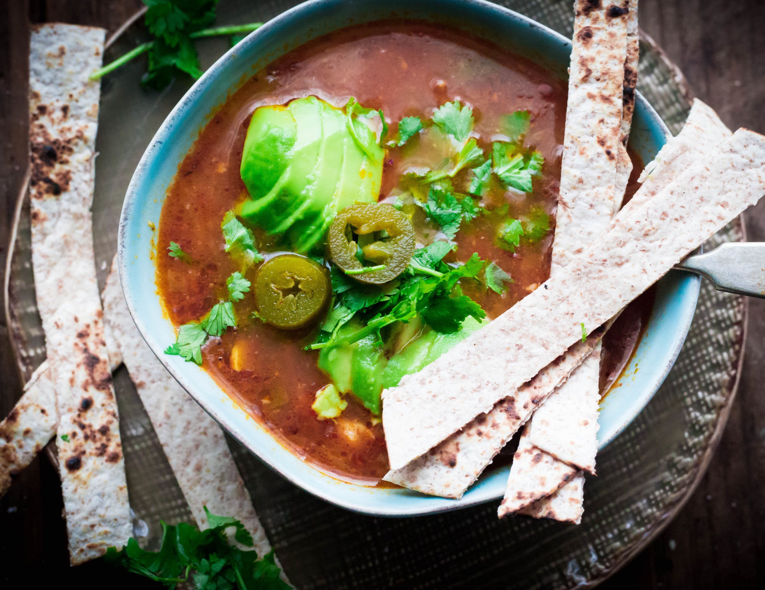 Chicken, Jalapeno and Lime Taco Soup in bowl with tortilla strips