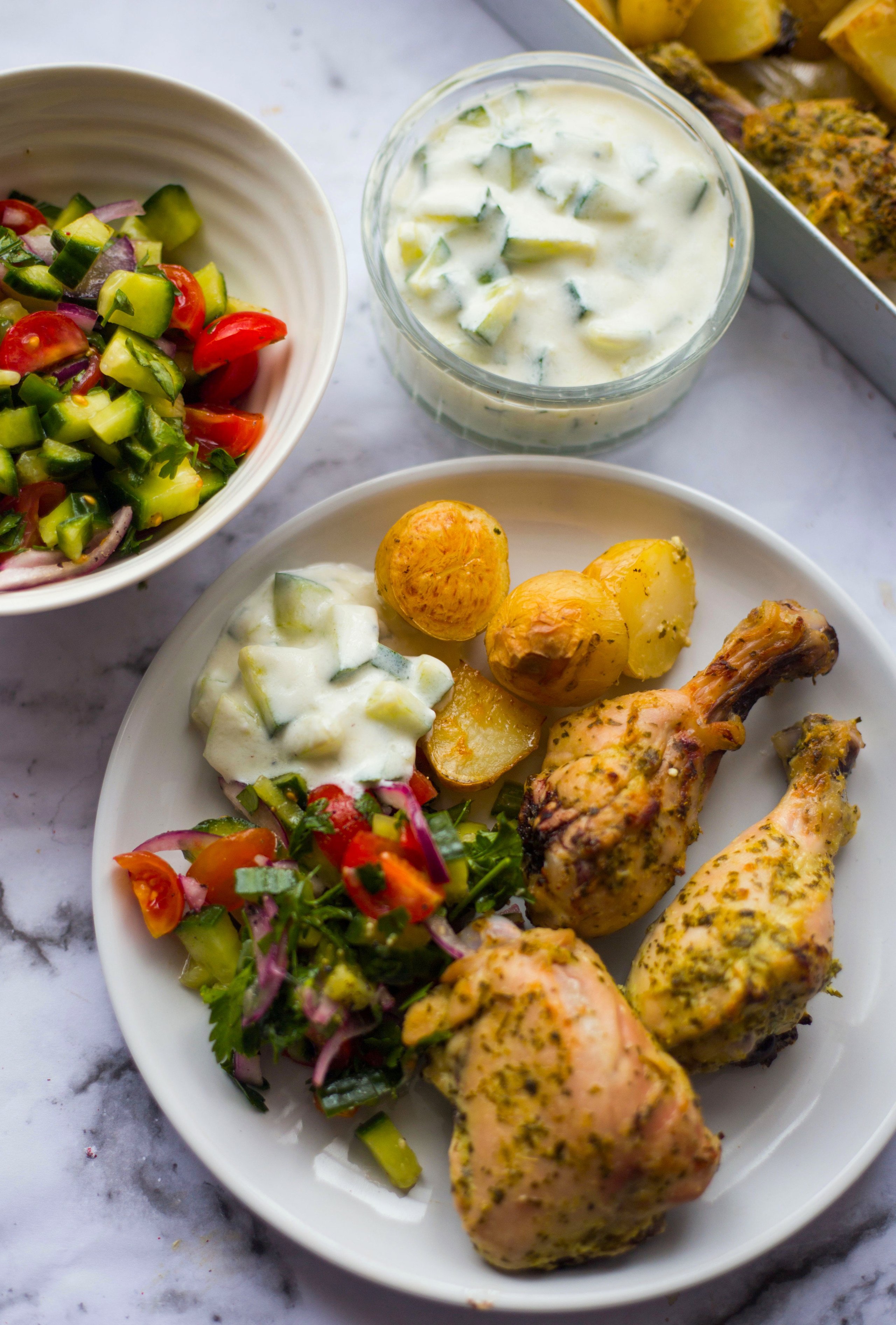 Greek chicken in a plate with potatoes and salad
