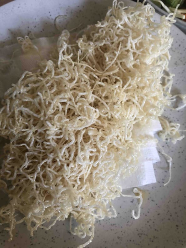 Noodles draining on kitchen towel on plate