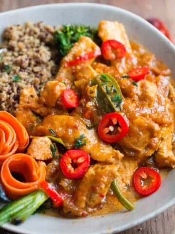 Thai Red Chicken Curry in bowl with quinoa, topped with red chillies