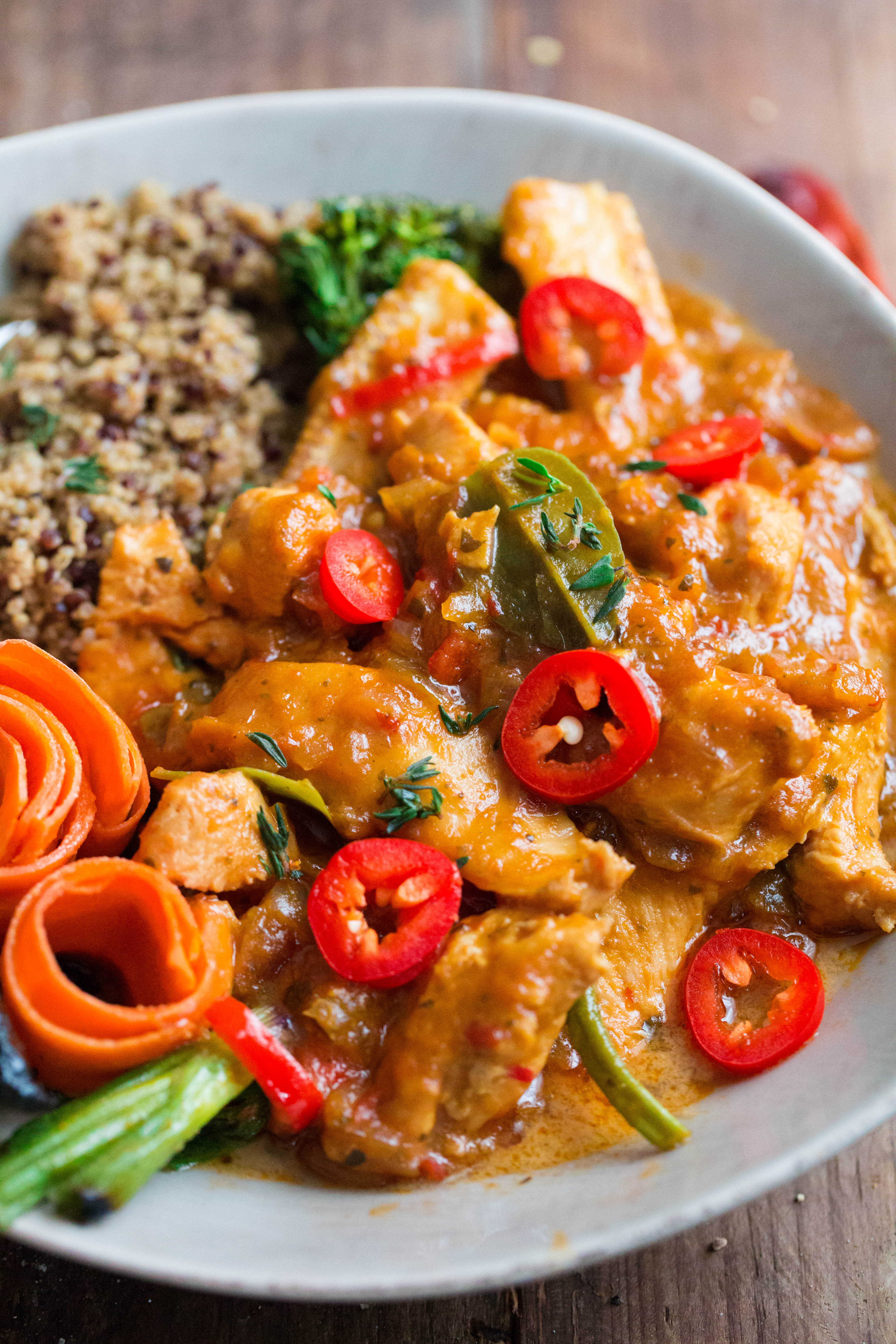 Thai Red Chicken Curry in bowl with quinoa, topped with red chillies