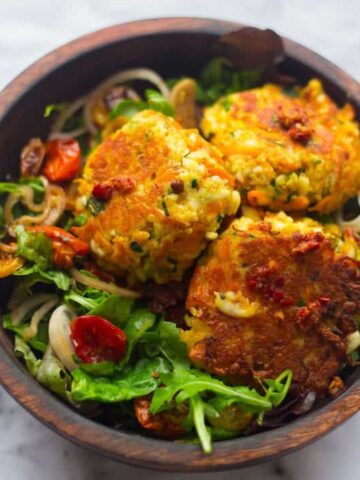 Gordon Ramsay's Courgette and Halloumi Fritters in wooden bowl with salad