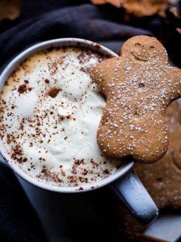 Gingerbread latte in cup with gingerbread cookie on top