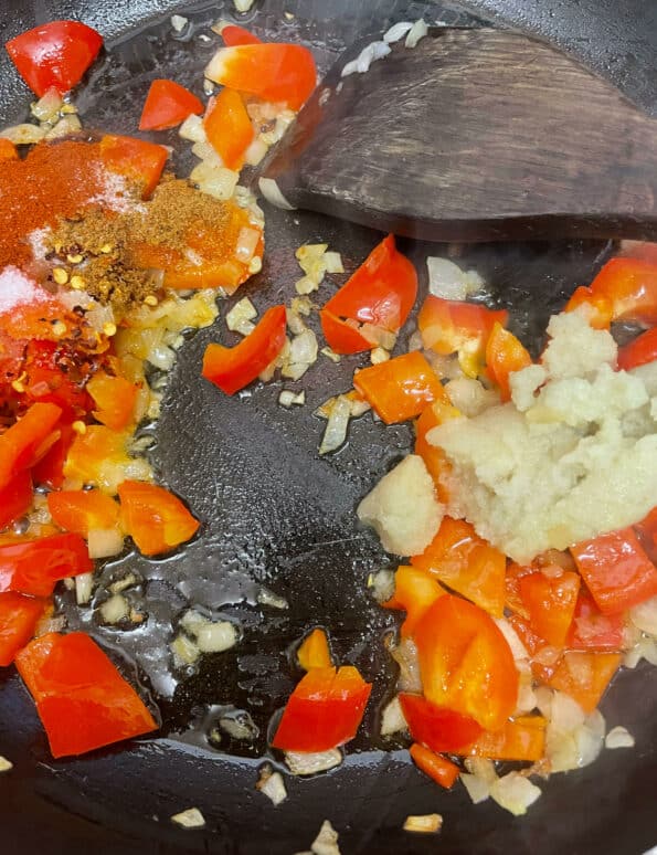 Spices added to vegetables in pan
