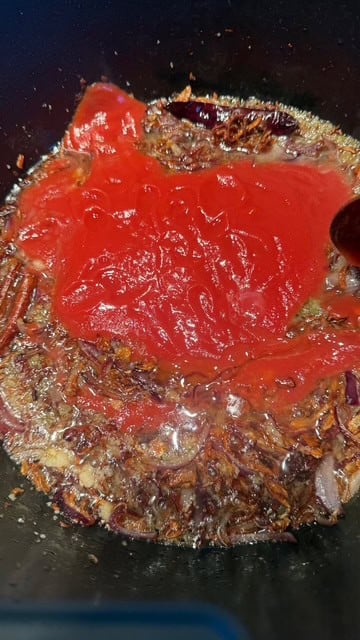 Add tomatoes - Cook covered on medium low until jammy and the oil begins to separate. Add chicken - Sauté until the chicken turns opaque and lightly browned. You' re not fully cooking it yet, just sealing. Add Spices - Add Salt, Turmeric, Cumin, Coriander, Paprika, Chilli Powder and Kashmiri Chilli Powder. Cook on medium high for 5 minutes. Add water + potatoes - Simmer on low. Add soaked rice - Gently fold it in don't overmix or you'll break grains. Steam on low - Bring to a boil, and when not much water remainins, cover the pot in a lsyer of foil and a lid. Let it cook for 20 - 25 minutes until the rice is tender and the chicken is fully cooked. Rest - Turn off heat, leave the lid on for 10 minutes. This allows steam to settle and grains to separate. Garnish with fresh coriander. Tomatoes in pot