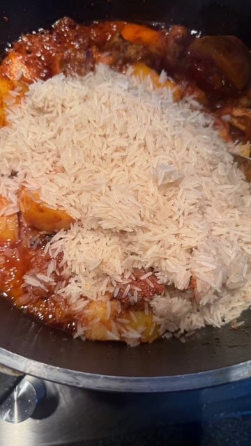 Chicken Akni - The BEST One Pot Chicken and Rice Pilau Rice added to pot