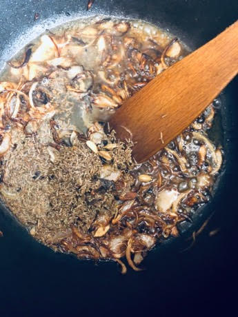 Browned Onions and spices in a pot with wooden spatula