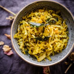 Cabbage Thoran in bowl with crispy curry leaves on top