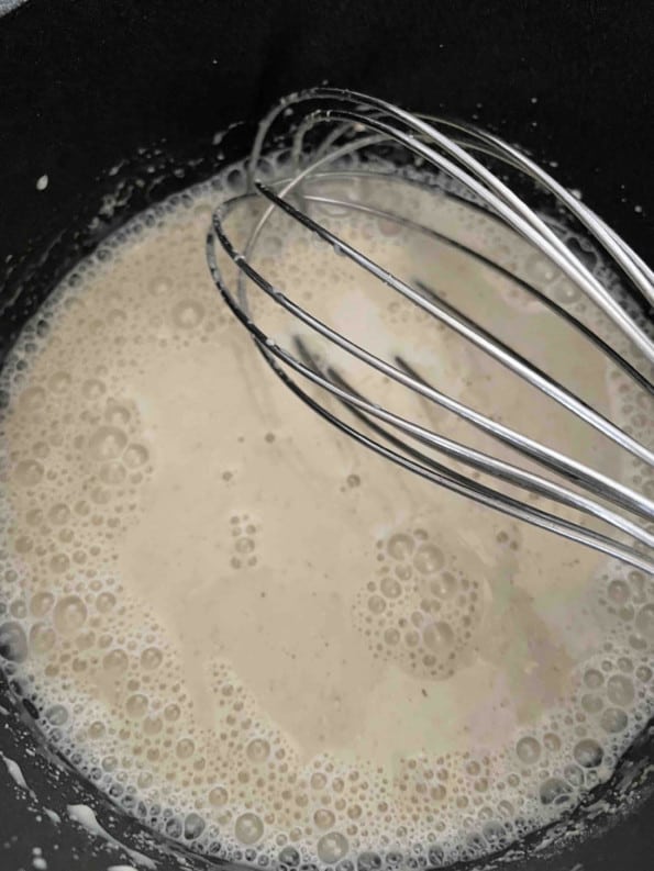 Barley Flour and milk with a whisk in a pot