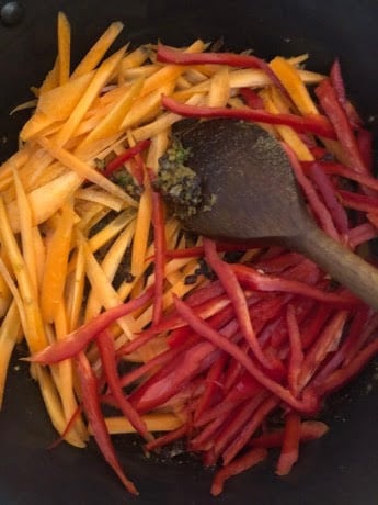 Red Peppers and Carrot in pot with wooden spoon