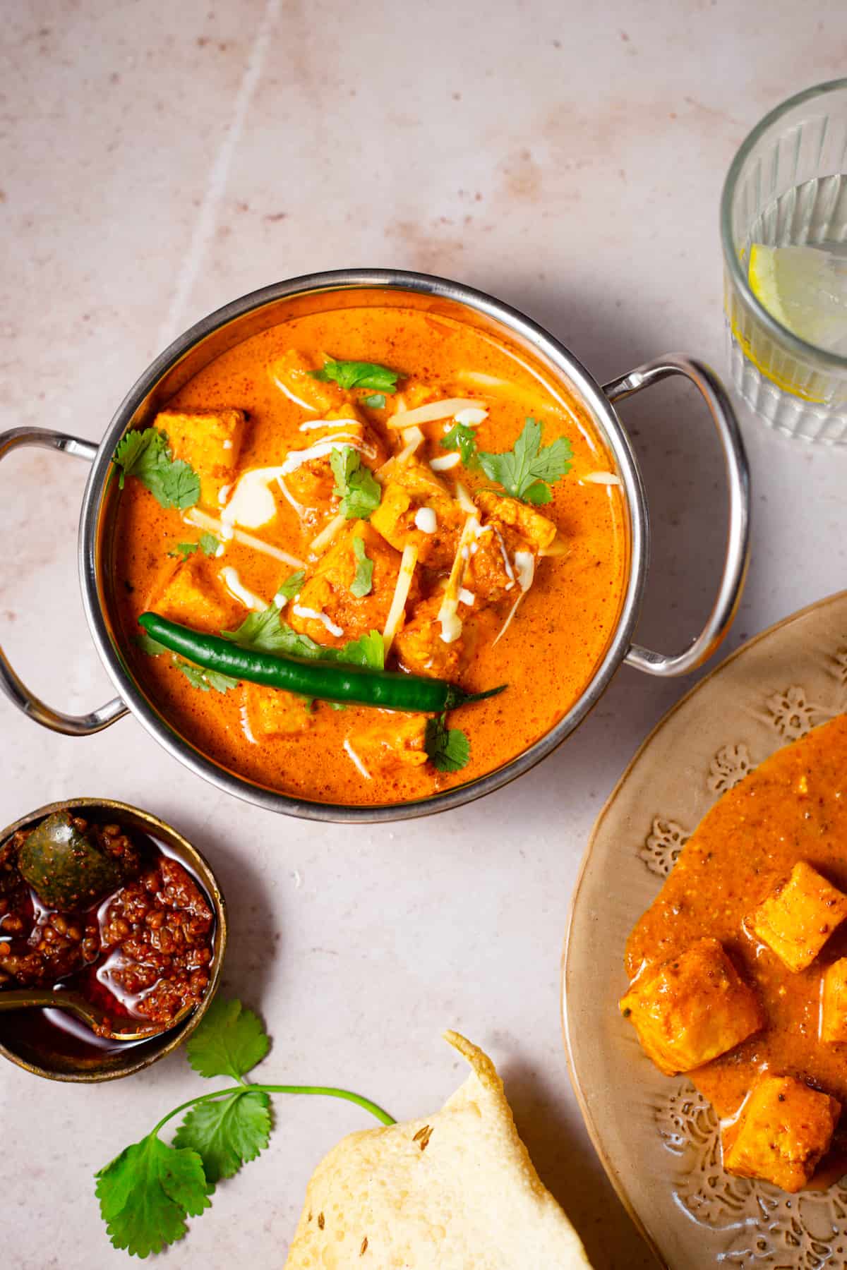 Paneer tikka masala in a dish with pickles and papadums