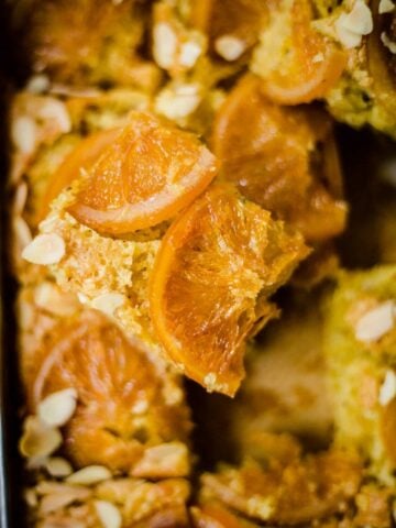 Orange cake sliced with almonds and crystallised oranges on top