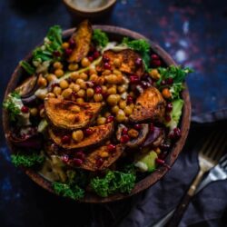 Kale salad with sweet potato , pomegranate and roast chickpeas in bowl
