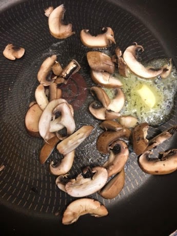 Butter and sliced mushrooms in pan