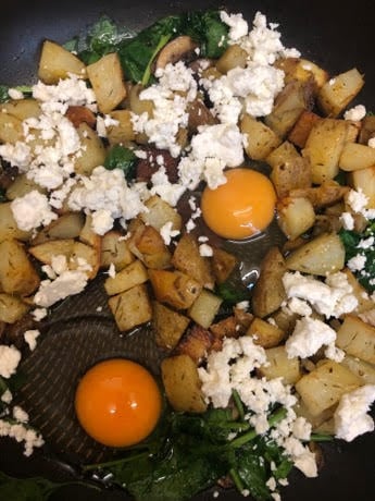 Potatoes, Feta, Spinach, Mushroom in pan and eggs in hollows
