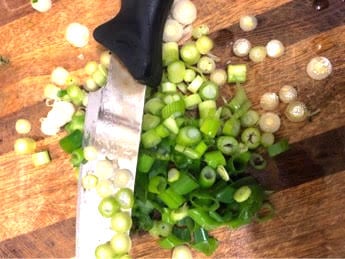 Chopped spring onions on a board