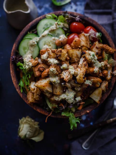 Roast cauliflower salad in a bowl with dressing to side