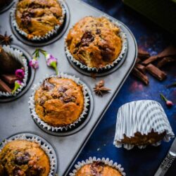 Banana and chocolate muffins in tin with spices scattered around