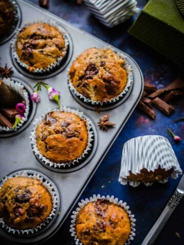 Banana and chocolate muffins in tin with spices scattered around