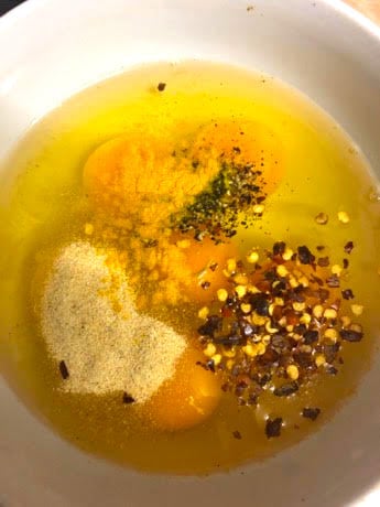 Eggs with seasonings and spices in bowl