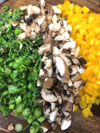 Peppers, mushrooms and broccoli on chopping board 