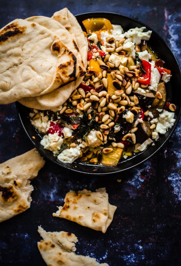 Roast veg with feta and pine nuts in bowl with flatbread to the side