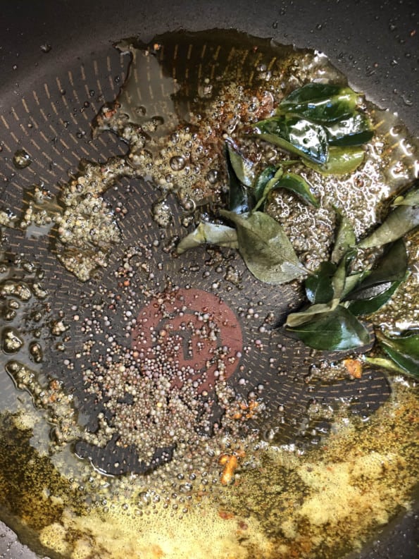 Curry Leaves and mustard seed in pan with oil 