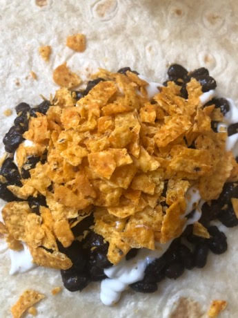 Black beans, sour cream and nachos on tortilla