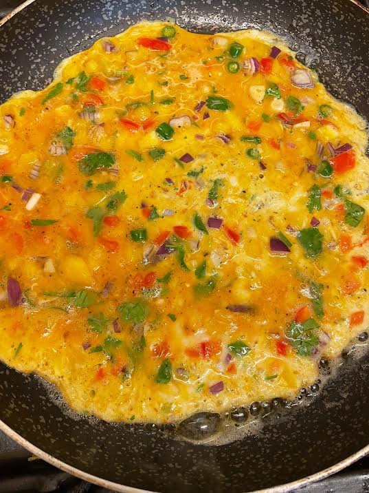 Omelette in pan with less egg on top