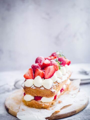Victoria Sandwich Loaf on a board with strawberries and cream deco